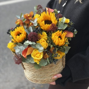 Композиция в сумке "Тональность" из подсолнухов, калл, ягод вибирнума, лимонных роз, скиммии и орхидеи в Луховицах